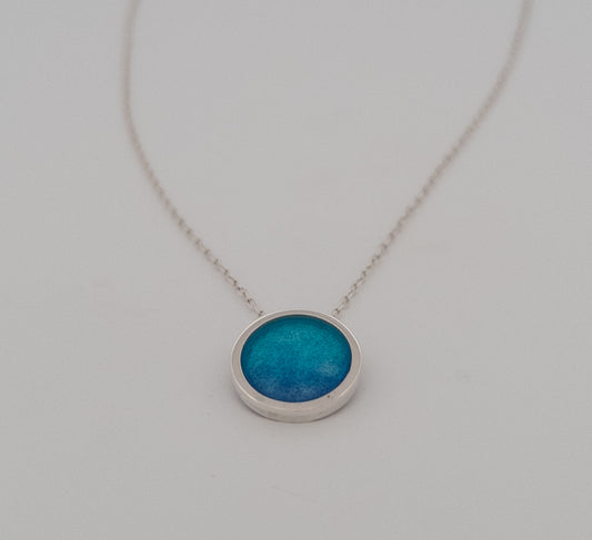 Circular textured necklace with peacock blue enamel.